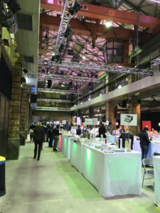 Das Foto zeigt eine große Halle mit vielen Büchertischen.