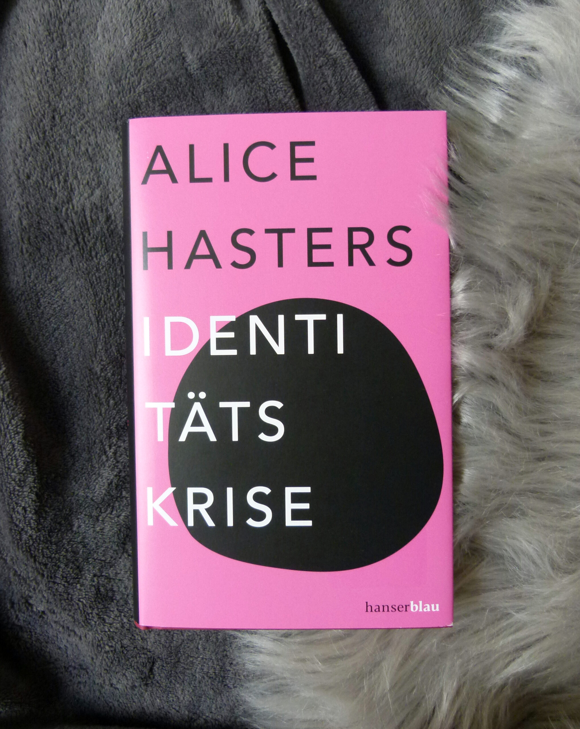 Das Buch liegt auf zwei grauen Decken.