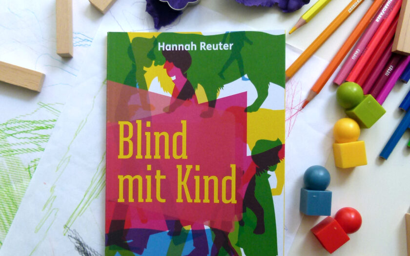 Das Buch liegt zwischen jeder Menge Kinderspielzeug und gemalten Bildern: Knete, Buntstifte, Bauklötze und Spielfiguren liegen überall verteilt.