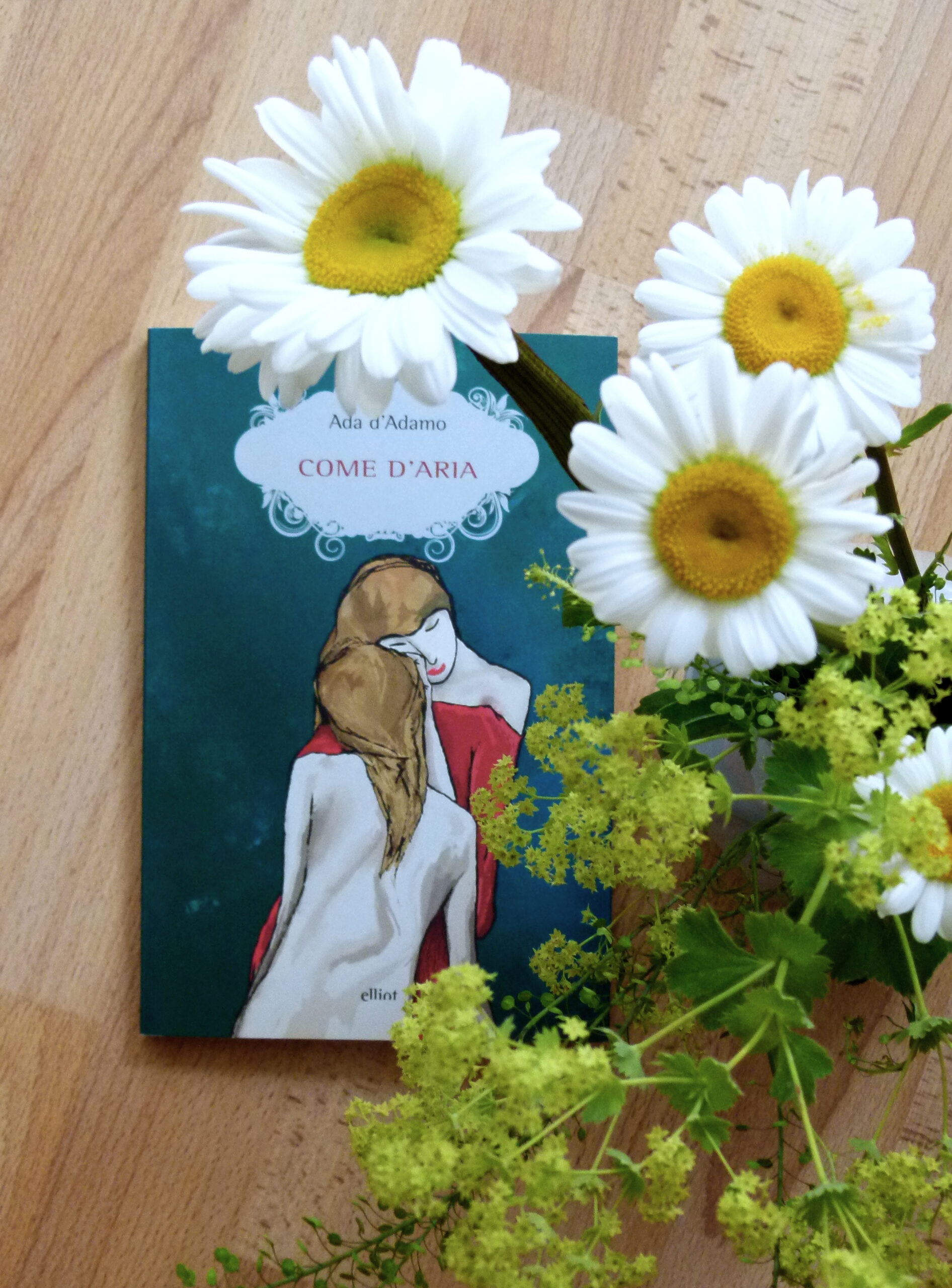 Das Buch liegt unter einem Strauß Margeriten.